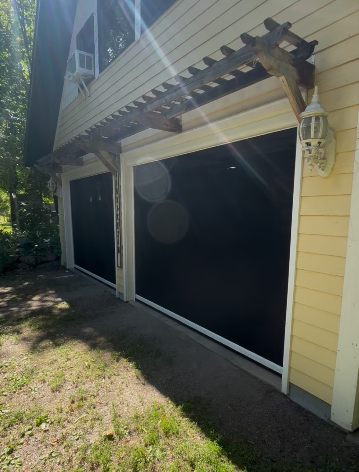 Retractable garage screens on a two-car garage with pergola